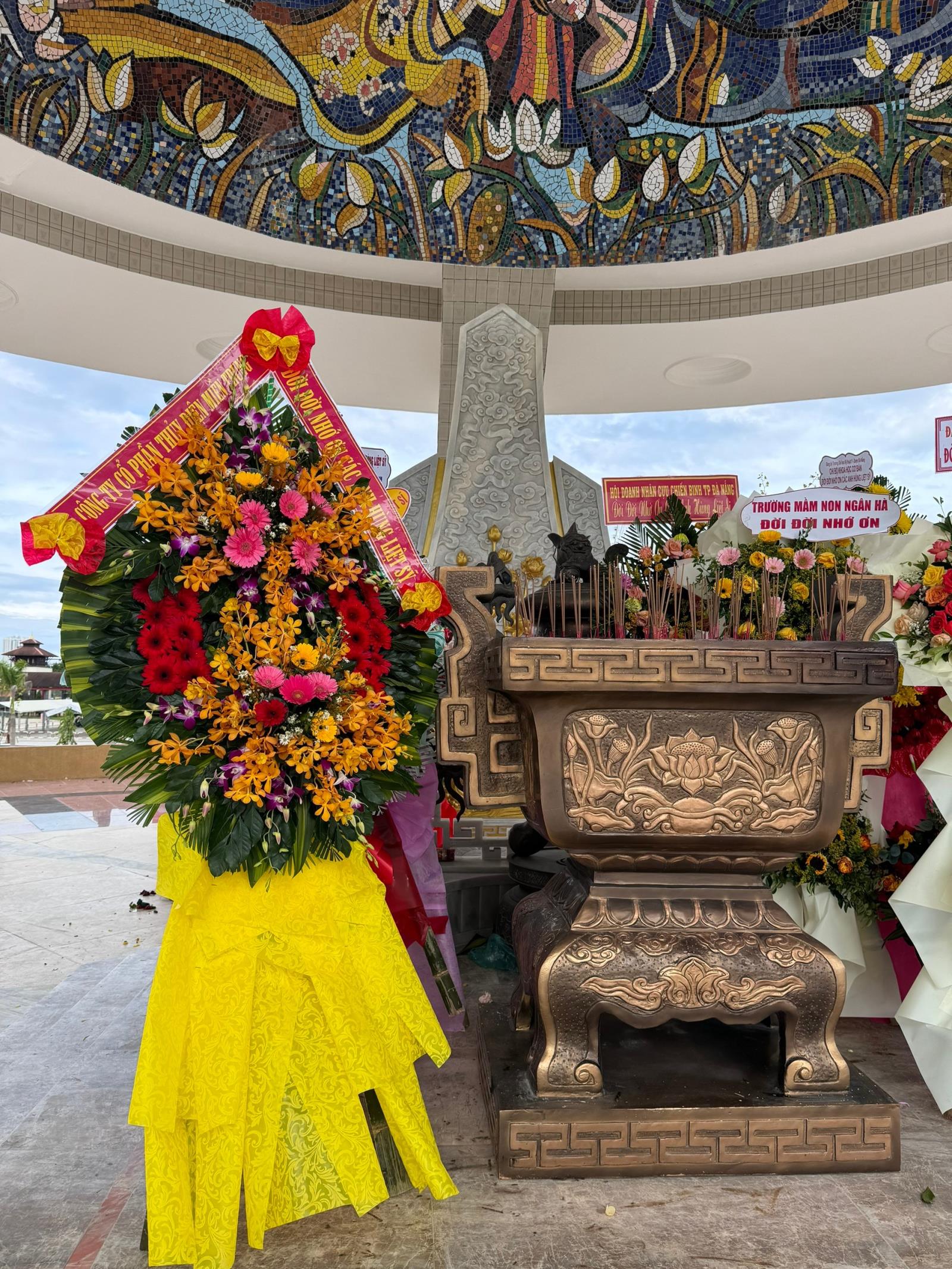 A large bouquet of flowers next to a shrine

Description automatically generated